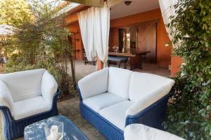 2 divani bianchi posti su un patio con tavolo di Borgo Caere a Ladispoli