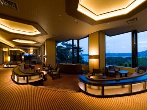 a hotel lobby with tables and chairs and large windows at Jodogahama Park Hotel in Miyako