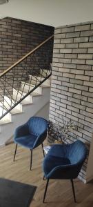 two blue chairs sitting next to a staircase at Apartman 25 in Belgrade