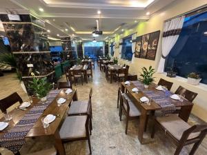 Sapa Adam Hotel في لاو كاي: مطعم بطاولات وكراسي خشبية في الغرفة