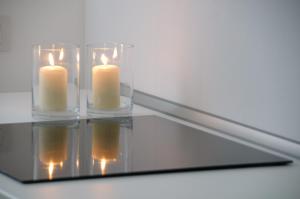 deux bougies dans un récipient en verre sur un miroir dans l'établissement Appartamenti Cervia, à Cervia