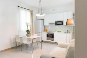 a kitchen and living room with a table and chairs at Eco Apartments Cervia in Cervia