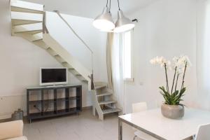 a living room with a staircase and a table with a tv at Eco Apartments Cervia in Cervia