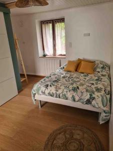 Schlafzimmer mit einem Bett, einem Fenster und einem Teppich in der Unterkunft Joli appartement avec coin jardin in Chalon-sur-Saône