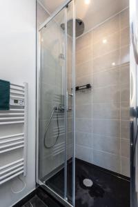 La salle de bains est pourvue d'une douche avec une porte en verre. dans l'établissement Le Garden B avec salle de sport, à Rouen