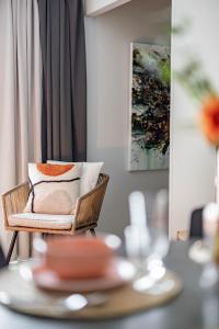 a rattan chair with pillows on top of a table at Arctic Golden Sun City Suite in Rovaniemi