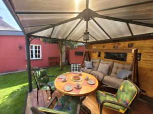un patio con una mesa y un sofá bajo una tienda de campaña en FeWo Zum Laacher See en Mendig