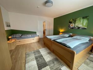 1 dormitorio con 2 camas y pared verde en FeWo Zum Laacher See en Mendig