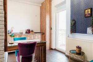 cocina con escritorio y sillas moradas en AZUR CYAN HOUSE, en Bucarest