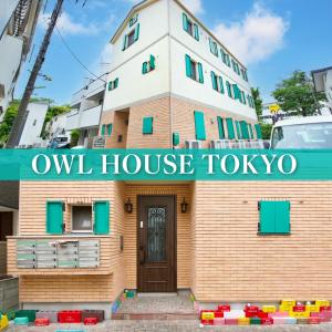 een gebouw met een bord waarop staat: uilenhuis tokyo bij オウルハウス in Tokyo