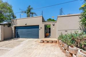 a garage with a garage door in front of a house at Cozy 2 bedroom garden cottage in Melville in Johannesburg