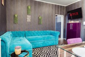 Un sofá azul en una sala de estar. en AZUR CYAN HOUSE, en Bucarest