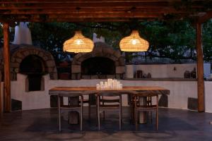 einen Holztisch und Stühle unter zwei Kronleuchtern in der Unterkunft Iliana Olive Branch in Adamas + 72 Fotos