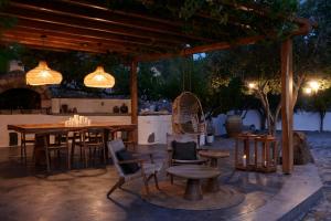 ein Restaurant mit einem Tisch, Stühlen und Lampen in der Unterkunft Iliana Olive Branch in Adamas