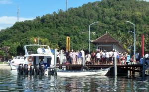 um grupo de pessoas em pé em uma doca com um barco em Gili Ferries ticket em Padangbai