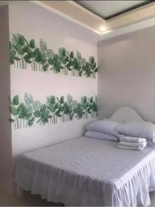 um quarto com uma cama com plantas verdes na parede em The Veehive Guesthouse em Cebu