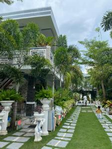 um jardim com palmeiras em frente a uma casa em The Veehive Guesthouse em Cebu