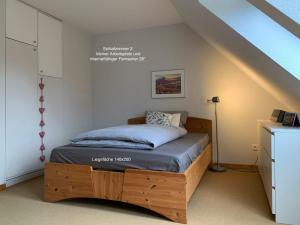 a bedroom with a wooden bed in a attic at DHH Kalkgrund - Haus Nordlichter in Wees