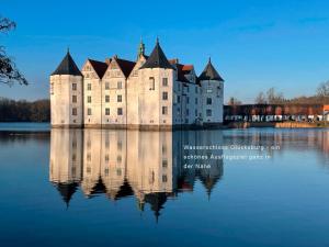 a castle on a lake with its reflection in the water at DHH Kalkgrund - Haus Nordlichter in Wees