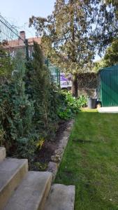 un jardin avec des escaliers, des plantes et une clôture dans l'établissement Les Acacias - Maison Orly, à Orly