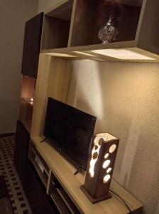a room with a tv and a table with a lamp at Les Acacias - Maison Orly in Orly +3 photos