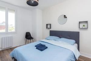 - une chambre blanche avec un grand lit et des oreillers bleus dans l'établissement Le Saint James B avec salle de sport, à Rouen