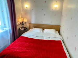 ein Schlafzimmer mit einer roten Decke auf einem Bett in der Unterkunft Lovely and quiet condo in Kristiine. Free parking. in Tallinn
