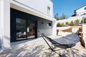 a hammock sitting outside of a house at Villa 33 Silver Coast in Nadadouro