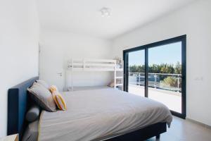 ein Schlafzimmer mit einem Bett und einem großen Fenster in der Unterkunft Villa 33 Silver Coast in Nadadouro + 49 Fotos