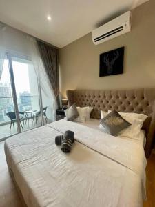 um quarto com uma grande cama branca e uma grande janela em Quill Residences em Kuala Lumpur