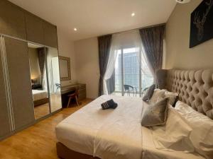 um quarto com uma cama grande e uma janela grande em Quill Residences em Kuala Lumpur