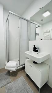 uma casa de banho branca com um lavatório e um chuveiro em Skyview Studio Apartments at Berlin Kreuzberg-Mitte em Berlim