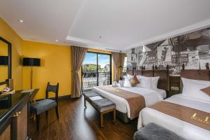 a hotel room with two beds and a balcony at Hanoi Lion Boutique Hotel in Hanoi