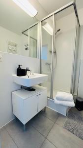 a white bathroom with a sink and a shower at Skyview Studio Apartments at Berlin Kreuzberg-Mitte in Berlin