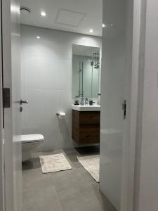 a bathroom with a toilet and a sink and a mirror at Oceans Lux 1 Bedroom - Seaview in Durban