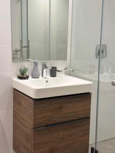 a bathroom with a white sink and a shower at Oceans Lux 1 Bedroom - Seaview in Durban