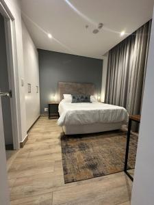 a bedroom with a white bed and a rug at Oceans Lux 1 Bedroom - Seaview in Durban