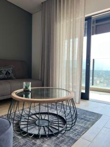 a living room with a glass table and a couch at Oceans Lux 1 Bedroom - Seaview in Durban