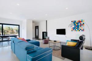 - un salon avec un canapé bleu et des chaises dans l'établissement Villa 33 Silver Coast, à Nadadouro
