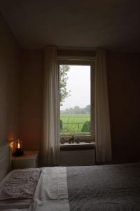 - une chambre avec un lit et une fenêtre avec un lavabo dans l'établissement Bosrijk Toevluchtsoord, à Harskamp