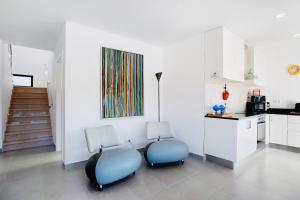 zwei Stühle in einer Küche mit einem Gemälde an der Wand in der Unterkunft Villa 33 Silver Coast in Nadadouro