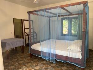 a bedroom with a canopy bed with a window at Villasiri and Leon Beach Paradise in Tangalle