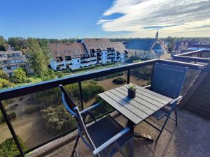 a table and chairs on a balcony with a view at Appartement met zeezicht, 2 balkons N & Z met prachtig verzicht en een gratis parkeerplaats in Koksijde