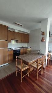 uma cozinha com mesa e cadeiras e uma cozinha com fogão em DÚPLEX SANABRIA em El Puente