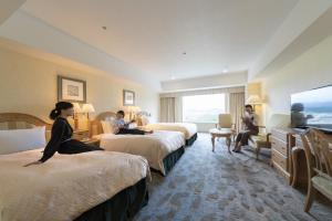 a hotel room with three people sitting on beds at Hotel Associa Takayama Resort in Takayama