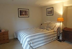 a bedroom with a bed and a lamp in it at Country garden retreat near Henley on Thames in Rotherfield Peppard