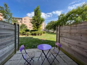 dwa fioletowe krzesła i stół na patio w obiekcie Acajou YourHostHelper w Caen