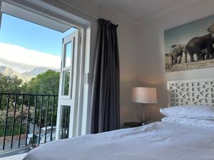 a bedroom with a bed and a large window at De Waterkant Piazza Apartments in Cape Town