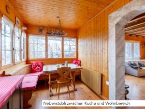 a dining room with wooden walls and a table and chairs at Chalet Müsli in Wildhaus