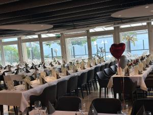 una fila de mesas en un salón de banquetes con un globo cardíaco en Boutique Hotel Riviera, en Spiez